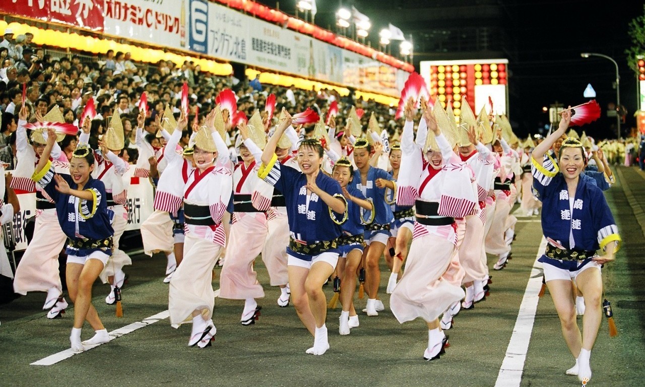 Dancers in traditional costume including straw hats parade at the Awa Dance Festival. This dance is popular at many Japanese summer festivals.